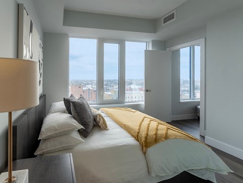 a bedroom with a bed and a view of the city