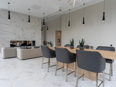 a dining room with a wooden table and grey chairs