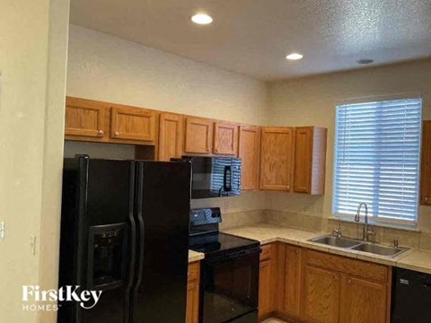 a kitchen with a black refrigerator and a sink