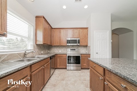 a kitchen with wooden cabinets and granite counter tops