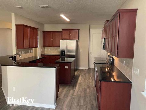 A kitchen with dark wood cabinets and a white refrigerator.