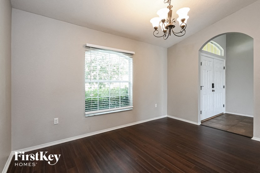 an empty living room with wood floors and a large window