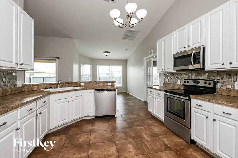 a large kitchen with white cabinets and stainless steel appliances