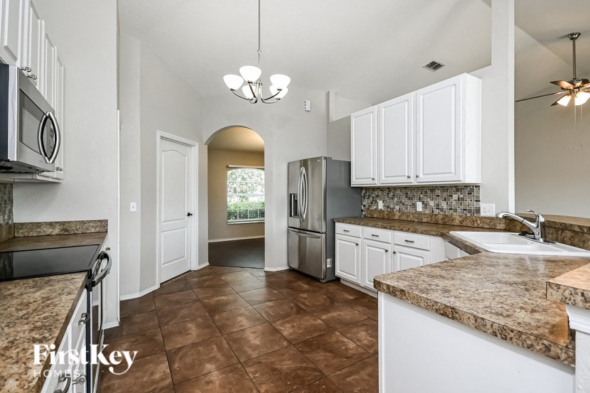a kitchen with white cabinets and a stainless steel refrigerator