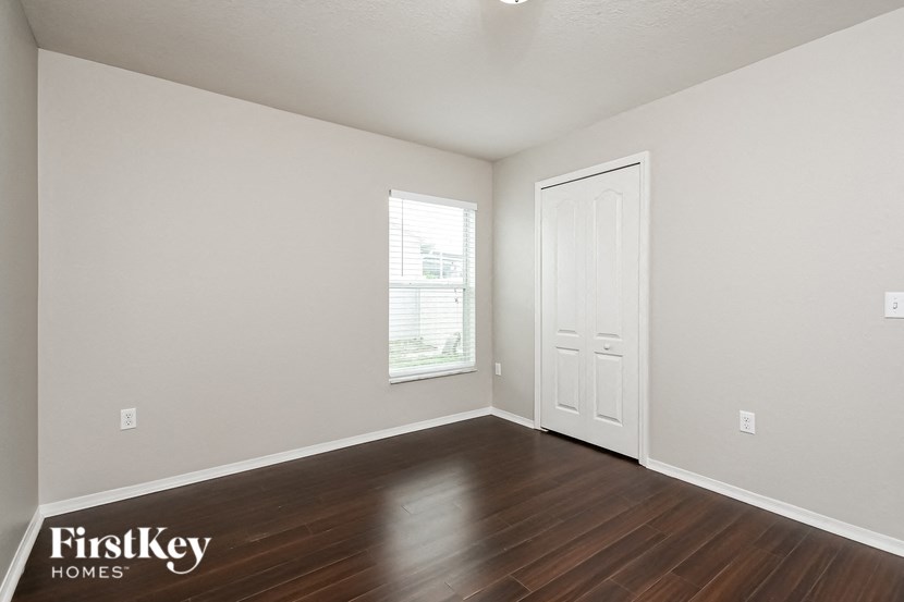 the living room of a home with wood flooring and a white door