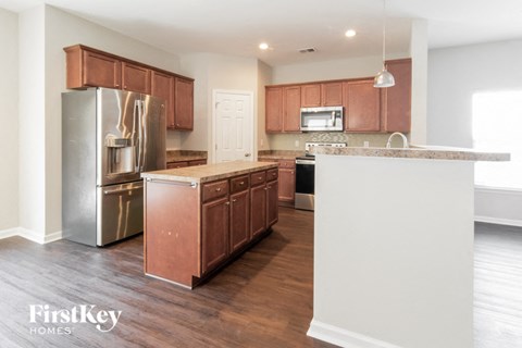 A kitchen with wooden cabinets and a stainless steel refrigerator.