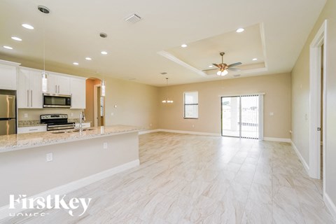 an empty kitchen and living room with a ceiling fan