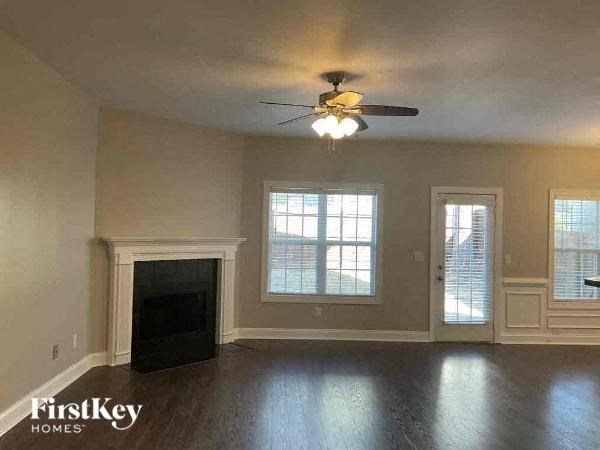 an empty living room with a ceiling fan and a fireplace