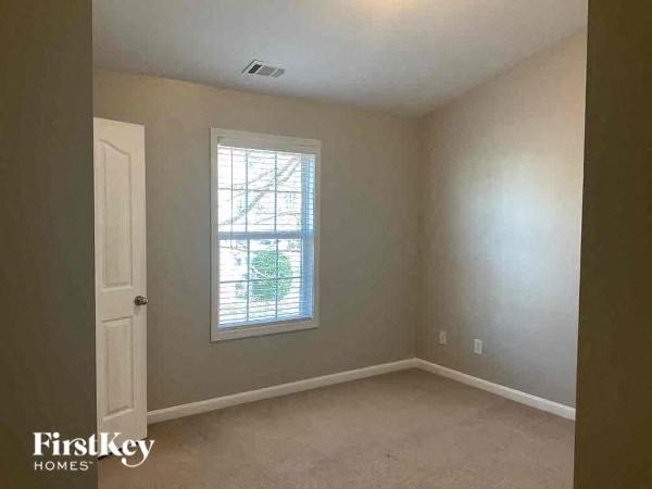 an empty room with a window and a white door