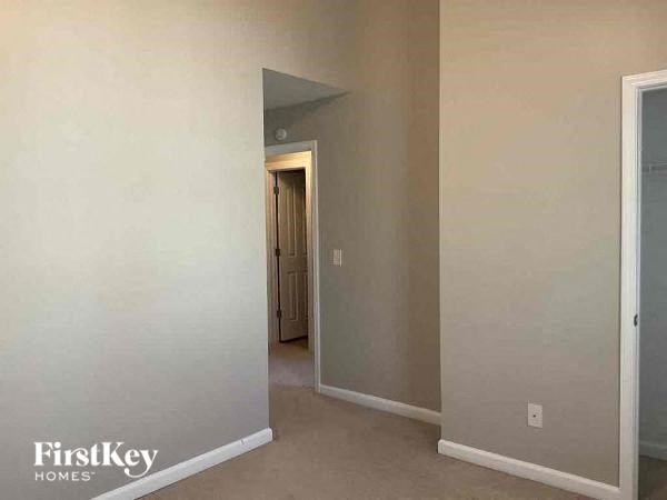an empty room with a hallway and a door to a closet