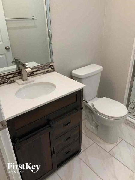 a bathroom with a toilet and a sink and a mirror