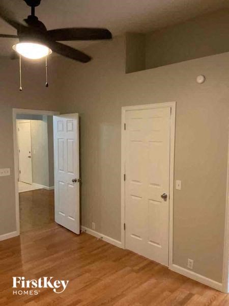 a living room with a ceiling fan and a white door