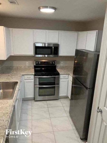 a kitchen with stainless steel appliances and white cabinets