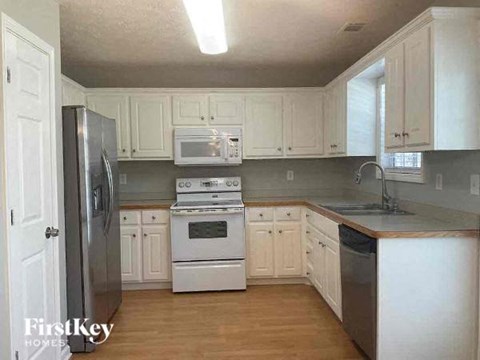 a kitchen with white cabinets and a stove and a refrigerator