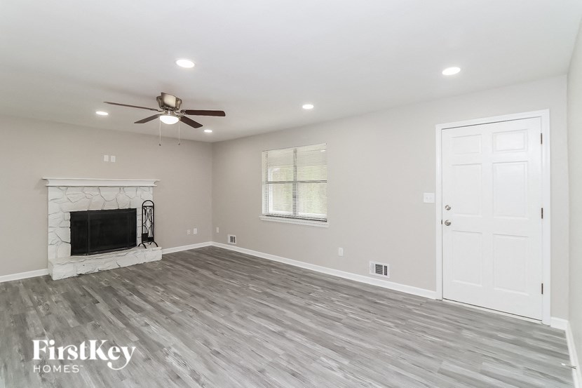 A spacious room with a fireplace and a ceiling fan.