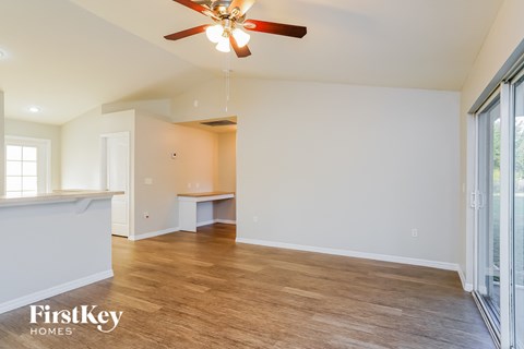 a living room with white walls and a ceiling fan
