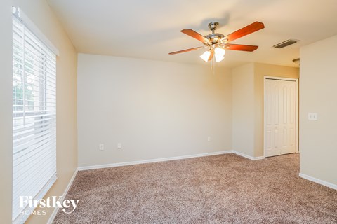 a bedroom with a ceiling fan and a window