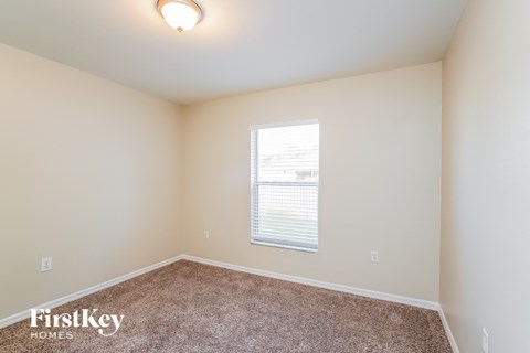 a spacious room with carpet and a window