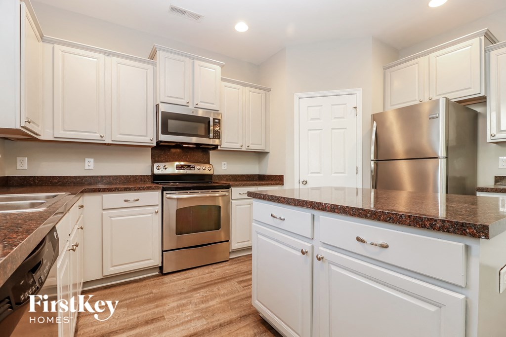 a kitchen with white cabinets and stainless steel appliances