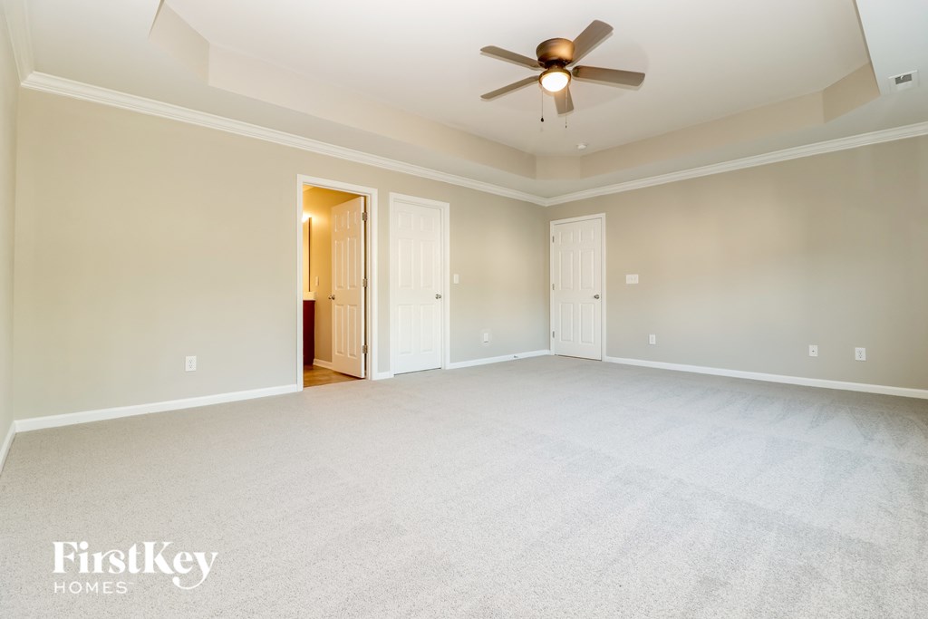 an empty living room with a ceiling fan