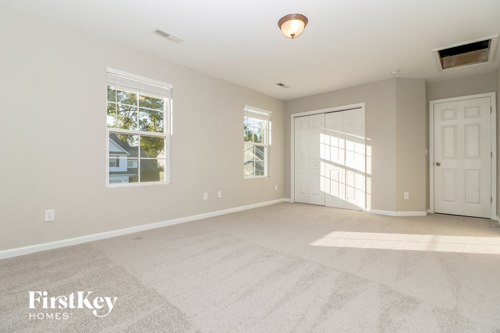 a empty living room with a white door and window