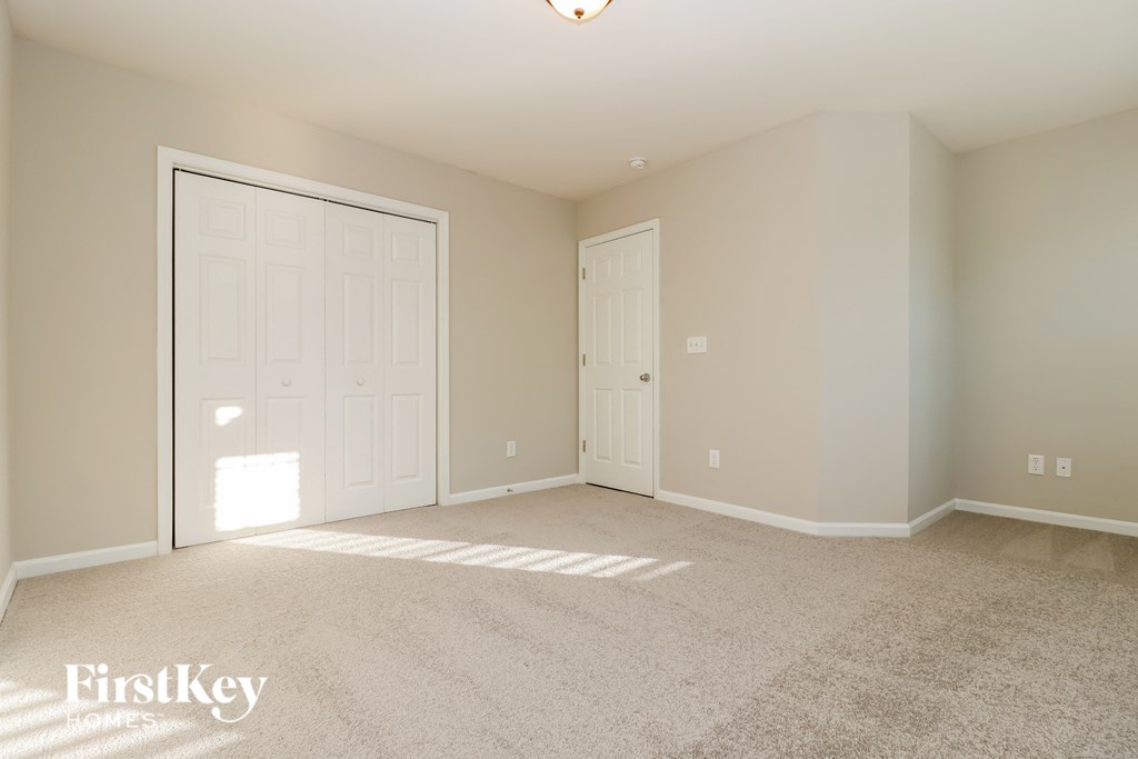 a bedroom with two doors and a carpeted floor