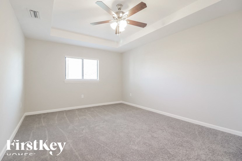 a empty room with a ceiling fan and a window