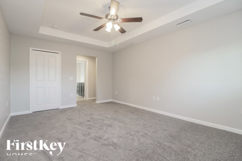 an empty living room with a ceiling fan