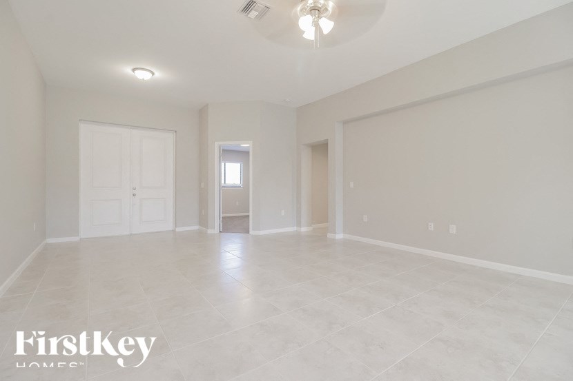 an empty living room with a door to a hallway