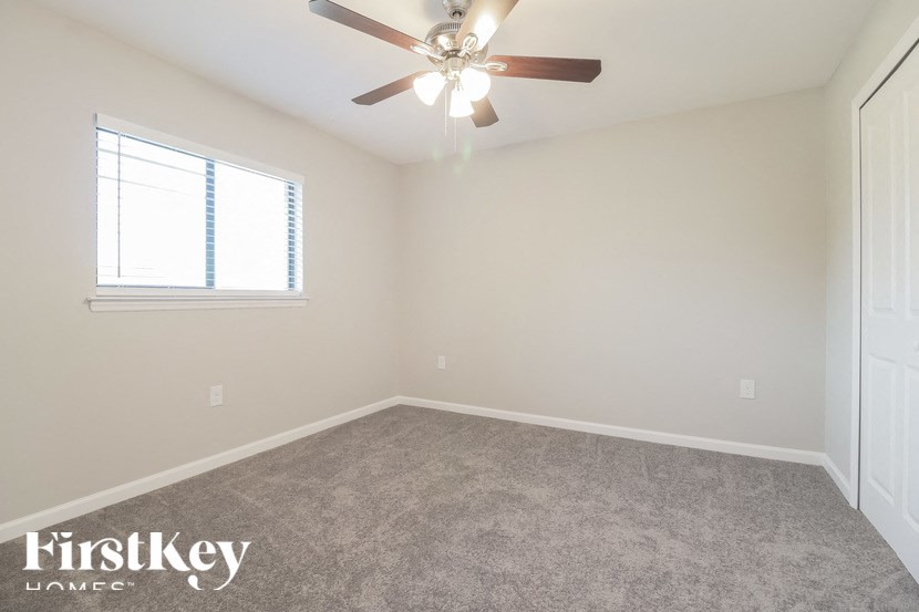 a bedroom with a ceiling fan and a window