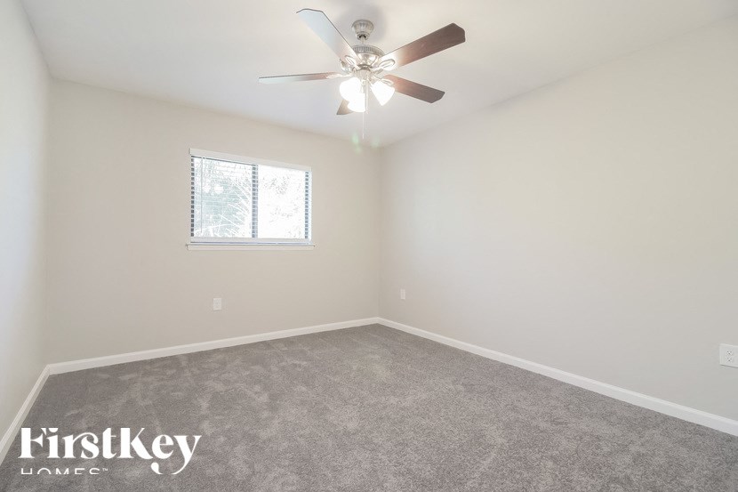 an empty room with a ceiling fan and a window