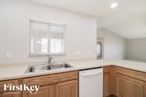 a kitchen with a sink and a dishwasher and wooden cabinets