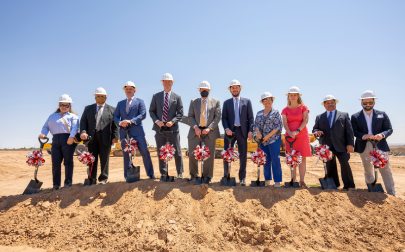a group of people standing on top of a dirt mound with shovels