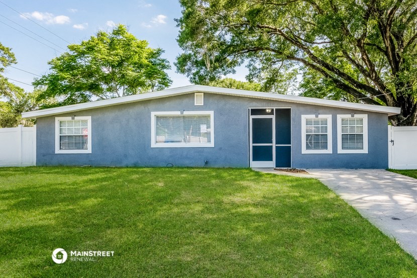 a blue house with a lawn and a blue door