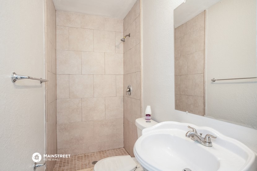 a bathroom with a sink and a shower and a toilet