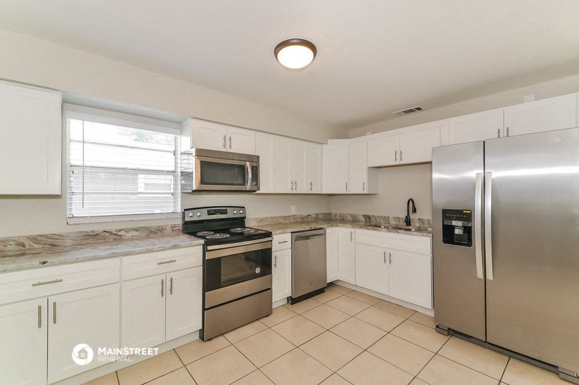 a kitchen with white cabinets and stainless steel appliances