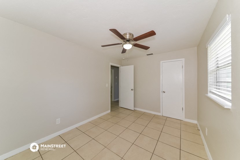 a living room with a ceiling fan and a tiled floor