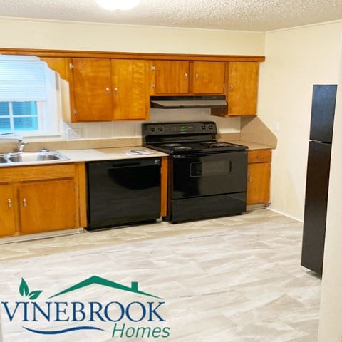 a kitchen with black appliances and wooden cabinets