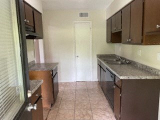 A kitchen with brown cabinets and a white door.