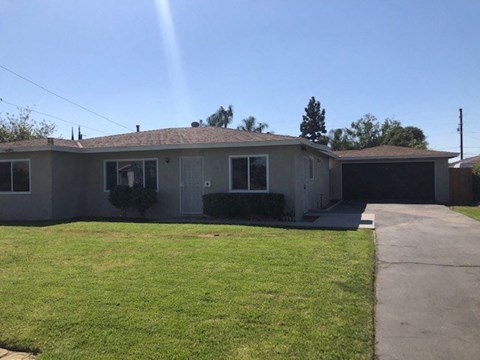 A house with a grey roof and a green lawn.