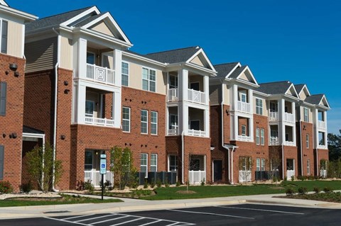 a row of brick and white apartment buildings on a street