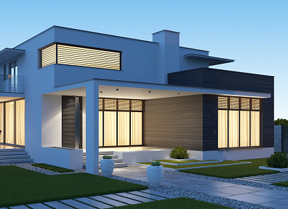 A modern house with a white and blue exterior and a well-manicured lawn.