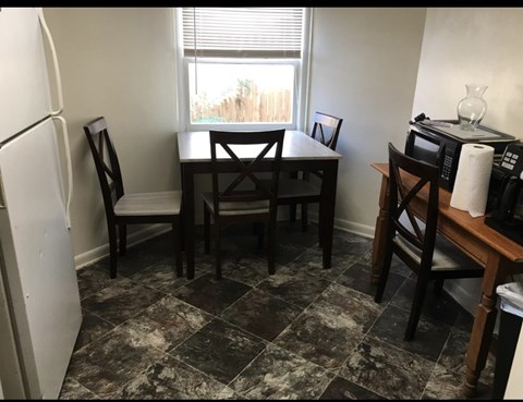 A kitchen with a table and chairs.