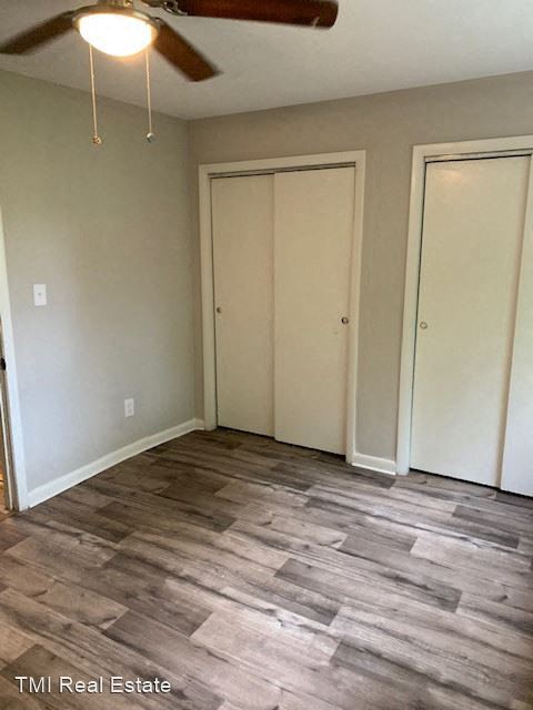 a living room with a wood floor and a ceiling fan