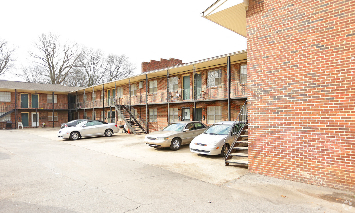 the parking lot is full of cars in front of a brick building