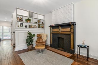 a living room with a brick fireplace and a chair