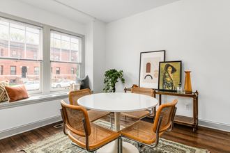 a dining room with a large window and a table and chairs
