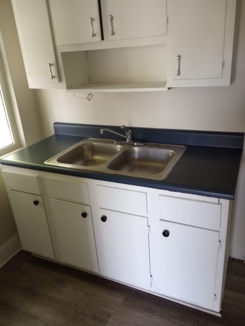 a kitchen with a sink and white cabinets