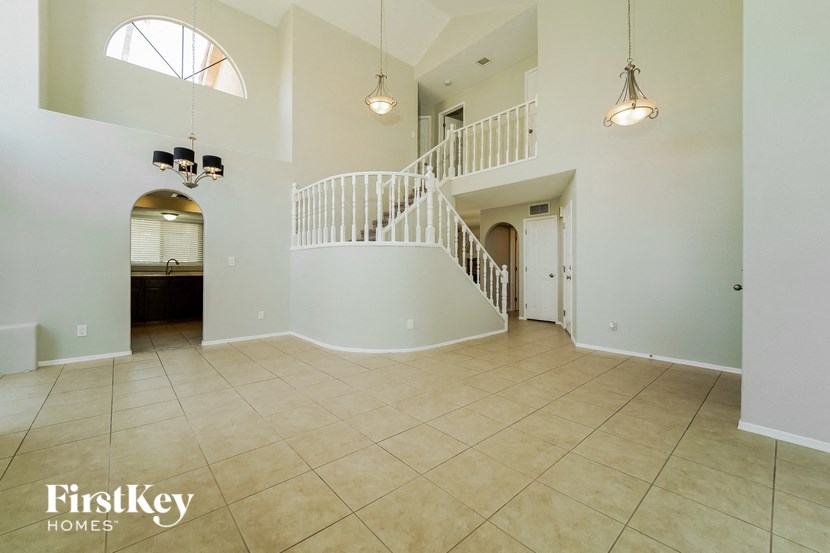 the foyer and living room of a house with a staircase