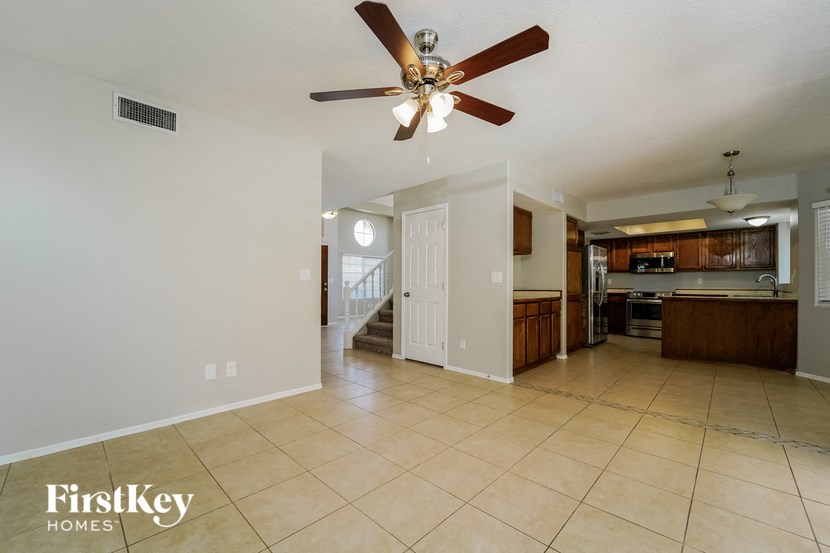 a kitchen and a living room with a ceiling fan